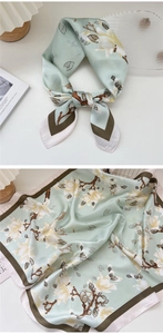 Detail of silk square scarf featuring white magnolia floral print and silky texture