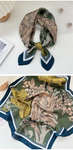 Detailed view of floral silk scarf featuring dark green base and vibrant yellow flowers
