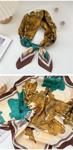 Detailed close-up of silk square scarf featuring floral prints, dragonflies, and butterflies