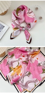 Close-up of pink lily floral print on square silk scarf with brown border detail