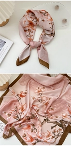 Detail of a pink silk floral square scarf with brown borders and elegant magnolia prints