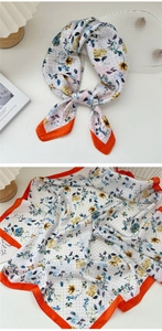 Detail of floral silk scarf featuring grid pattern and orange satin borders for women