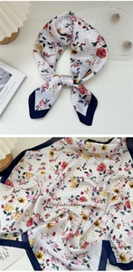 Macro detail of floral pattern silk scarf with dark blue border and cream background