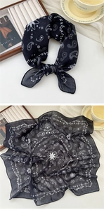 Detailed view of a soft black cotton linen scarf with white paisley patterns and wavy edges