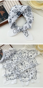 Close-up of white paisley cotton linen scarf featuring delicate floral prints and hemmed edges