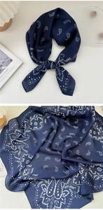 Dettaglio di un foulard di seta blu navy con motivo paisley e fiori bianchi chic