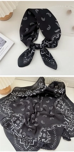 Dettaglio di un foulard di seta bianco e nero con motivo paisley e texture eleganti