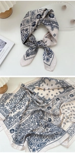 Dettaglio foulard in seta crema con motivi paisley vintage e finitura satinata
