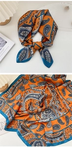 Dettaglio di foulard in seta con motivi paisley arancioni e bordi blu in stile francese