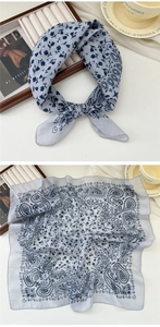 Detail view of a lightweight cotton-linen paisley scarf with floral patterns in blue and grey
