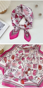 Dettaglio di un foulard quadrato di seta rosa con motivi di borse e occhiali alla moda