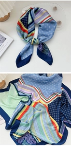 Dettaglio di un foulard di seta con motivi geometrici e trama liscia su un vassoio