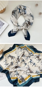 Dettaglio di un foulard in seta quadrato con stampa equestre in blu, giallo e crema