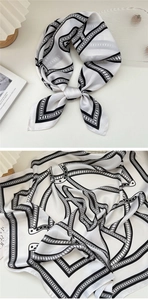 Dettaglio di un foulard di seta bianco e nero con elegante motivo a catena in stile francese