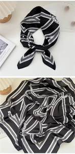 Dettaglio macro di un foulard di seta francese con motivi a catena bianchi e neri