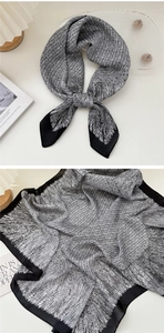 Dettaglio di un foulard in seta bianco e nero con motivi geometrici e bordi neri