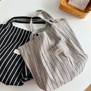 Minimalist striped canvas tote bag with outer pocket and shoulder straps for women