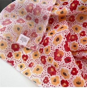 Detailed view of small floral scarf fabric showing 30% cotton 70% polyester care label