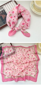 Detail of pink tulip floral silk scarf shown tied in a bow and laid flat on a table