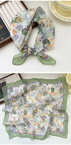 Detail of floral square scarf with green border and vintage blossoms on a table