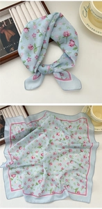 Detail of light blue square scarf featuring pink floral rose prints and silk texture