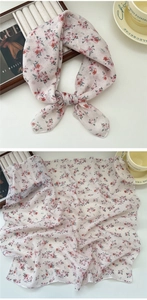 Close-up of lightweight floral silk scarf with pink flower print on beige fabric
