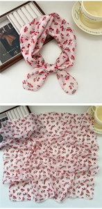 Macro detail of breathable pink cotton scarf with red cherry print and fine rolled edges