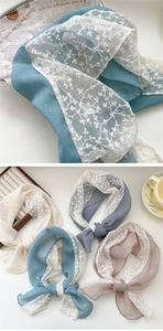 Close-up of elegant lace embroidery on cotton linen scarves in various pastel colors