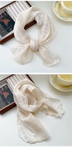 Close-up of beige cotton linen scarf with floral embroidery lace and French style texture