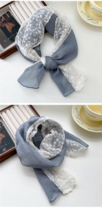 Detailed view of grey-blue scarf with white floral lace embroidery and chiffon texture