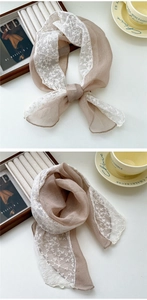 Detailed shot of light brown silk scarf with white floral lace embroidery and soft texture