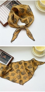 Macro detail of ginger paisley triangle scarf with delicate wavy embroidered edges