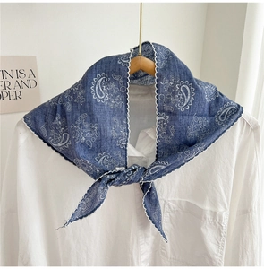 Close-up of blue paisley triangular scarf with white scallop lace trim and floral print