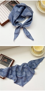 Close-up of blue paisley triangular scarf with scalloped edges and textured fabric