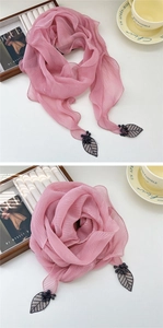 Détail d'une écharpe plissée rose avec pendentifs feuilles et fleurs en relief