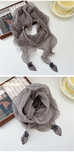 Détail d'une écharpe plissée taupe avec broderie de dentelle et perles délicates