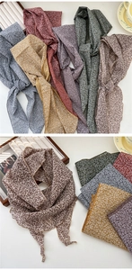 Detailed close-up of colorful floral print cotton linen scarves on a wooden tray