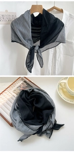 Detail of two-tone gray cotton scarf with intricate black lace trim edges