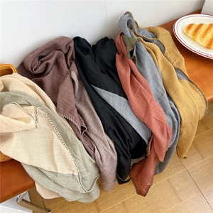 Diamond patterned cotton linen scarf in multiple colors on a wooden bench