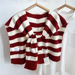 Detail of red and white striped knit shawl accessory styled over a white shirt collar