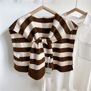 Detail of striped knitted shawl wrap on a white shirt showing texture and tie-up front