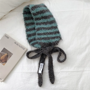 Détail du cache-col en maille mohair à rayures bicolores avec cordons et étiquette mode