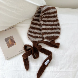 Gros plan détaillé sur l'écharpe en tricot à rayures marron avec étiquettes de mode