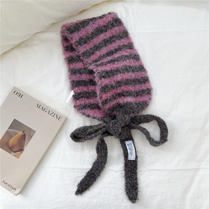 Détail de l'écharpe en maille rayée rose et gris avec texture douce et nœud