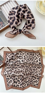 Détail d'un foulard en soie léopard noué en boucle avec une présentation de luxe à plat