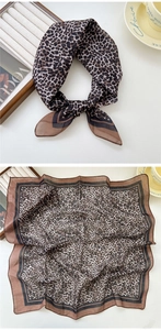 Détail macro d'un foulard en soie léopard avec bordure géométrique et texture lisse