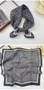 Gros plan du foulard léopard noir et blanc avec bordure rayée et texture légère