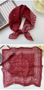 Détail d'un foulard en coton et lin rouge foncé avec motifs géométriques et bordures