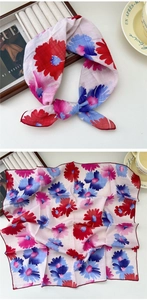 Close-up of floral cotton-linen square scarf with red rolled edges and artistic print