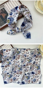 Detail of floral silk scarf with vintage pattern and fine hand-rolled blue edges